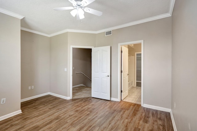 unfurnished bedroom featuring connected bathroom, ornamental molding, light hardwood / wood-style floors, and ceiling fan