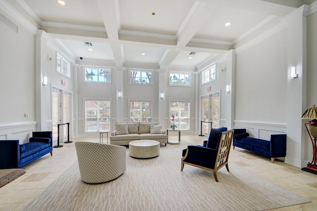 living room with beamed ceiling, a high ceiling, coffered ceiling, crown molding, and french doors