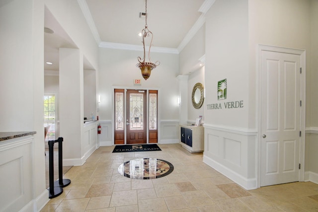 tiled entryway with ornamental molding and plenty of natural light