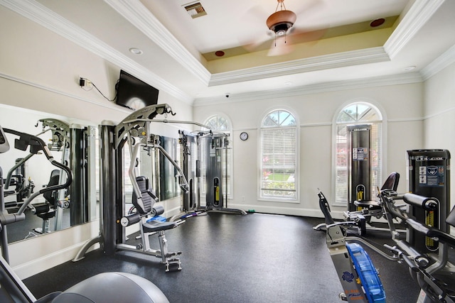 exercise room with a tray ceiling and ornamental molding