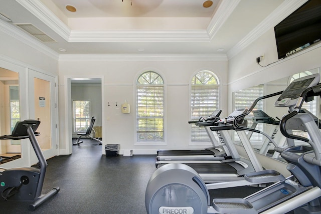 gym featuring crown molding and a tray ceiling