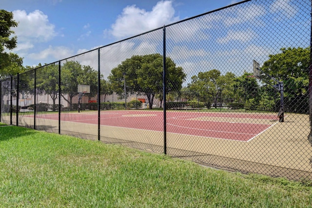 view of sport court featuring a yard and basketball hoop