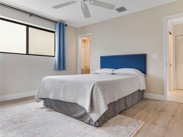 bedroom with light hardwood / wood-style flooring, ceiling fan, and ensuite bathroom