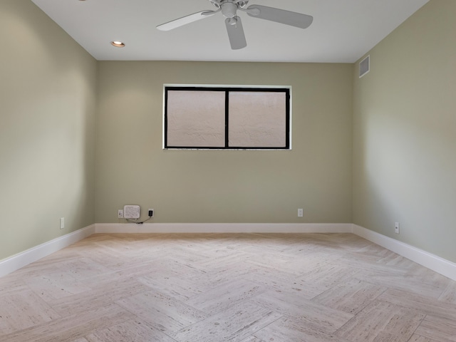 unfurnished room with ceiling fan and light parquet floors