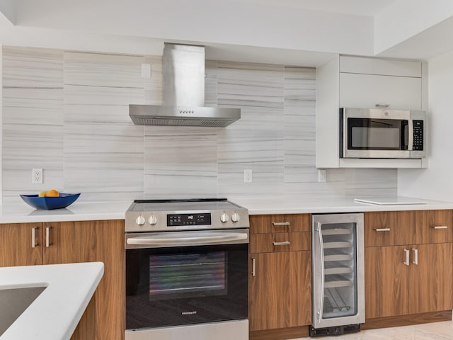 kitchen with wine cooler, wall chimney exhaust hood, appliances with stainless steel finishes, decorative backsplash, and white cabinets