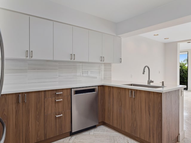 kitchen with sink, tasteful backsplash, dishwasher, kitchen peninsula, and white cabinets