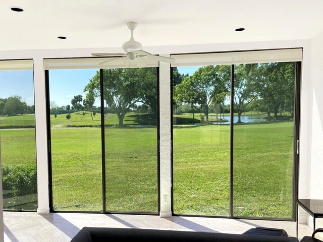 doorway featuring a wealth of natural light, ceiling fan, and a water view