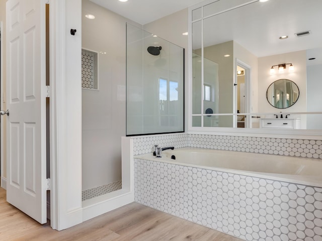 bathroom featuring hardwood / wood-style floors and separate shower and tub