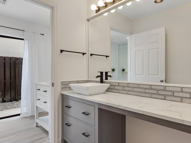 bathroom featuring tasteful backsplash, vanity, and wood-type flooring