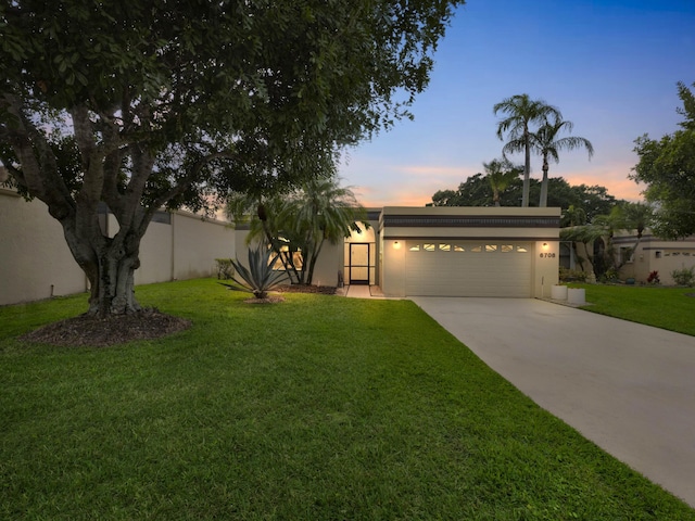 view of front of house with a garage and a yard