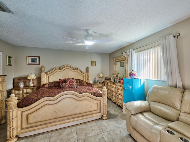 tiled bedroom featuring ceiling fan and a textured ceiling