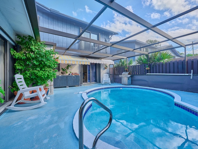 view of swimming pool featuring area for grilling, a patio, and glass enclosure