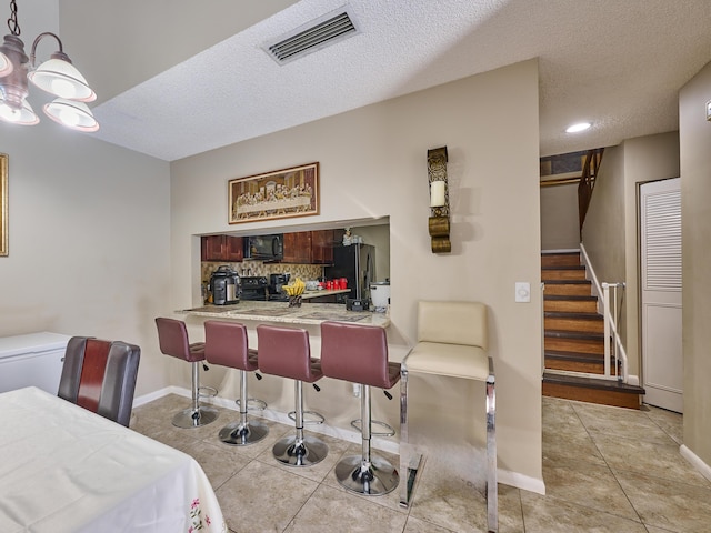 interior space featuring a textured ceiling and light tile patterned flooring