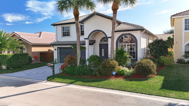 mediterranean / spanish house with a garage and a front lawn