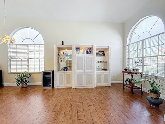 misc room featuring hardwood / wood-style floors, a notable chandelier, and beverage cooler