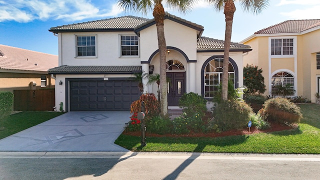 mediterranean / spanish home featuring a garage and a front lawn