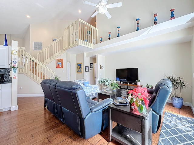 living room with wood-type flooring, high vaulted ceiling, and ceiling fan