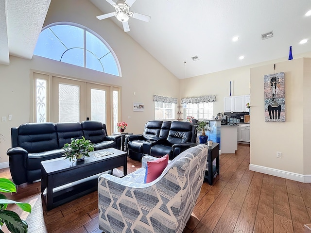 living room with hardwood / wood-style flooring, a healthy amount of sunlight, high vaulted ceiling, and french doors