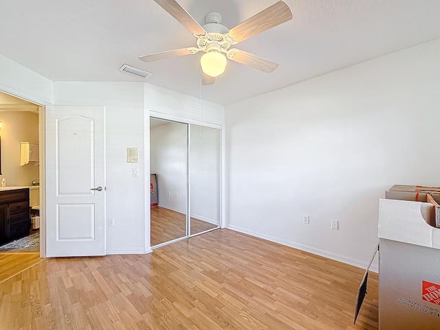 bedroom with ceiling fan, light wood-type flooring, and a closet