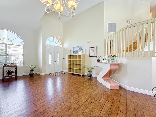 foyer featuring dark hardwood / wood-style floors, a chandelier, and high vaulted ceiling