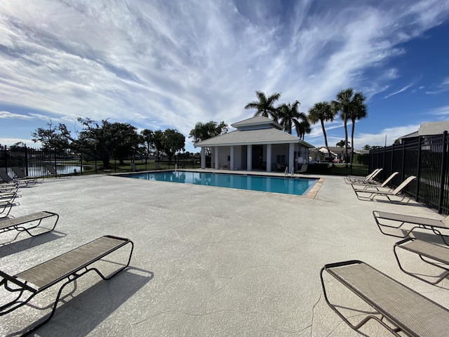 view of pool featuring a water view and a patio area