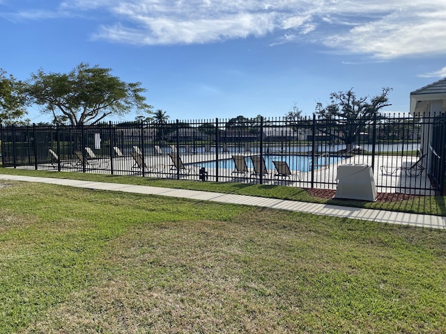 view of pool with a lawn