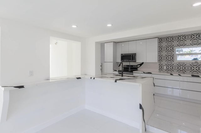 kitchen featuring sink, white cabinetry, tasteful backsplash, electric range oven, and kitchen peninsula