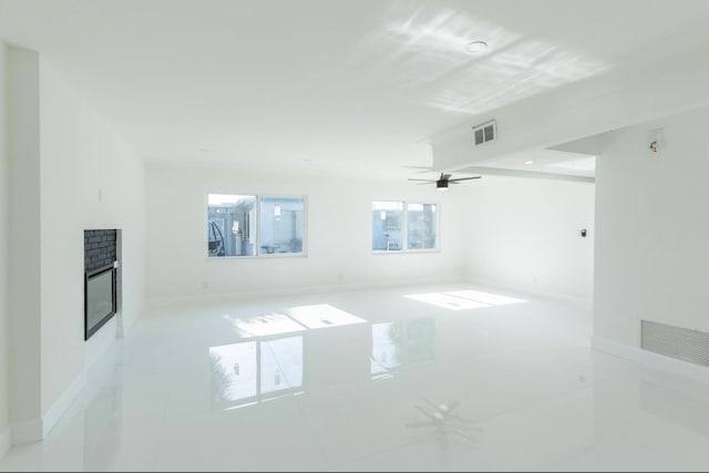 tiled empty room featuring ceiling fan