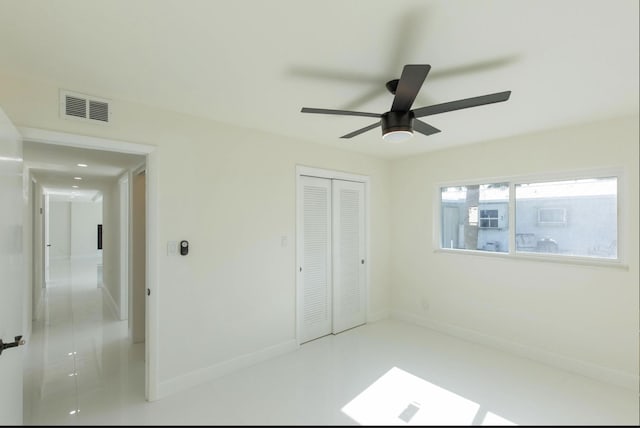 unfurnished bedroom featuring ceiling fan and a closet