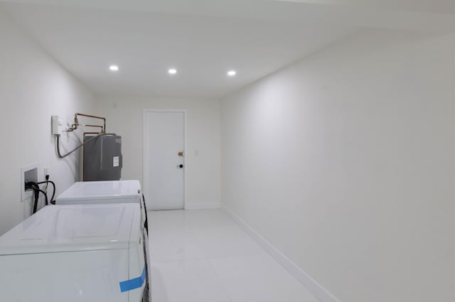 clothes washing area featuring washer and dryer and water heater