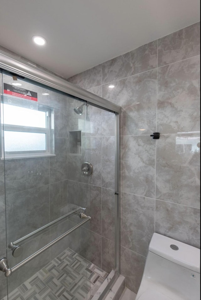 bathroom featuring walk in shower and toilet