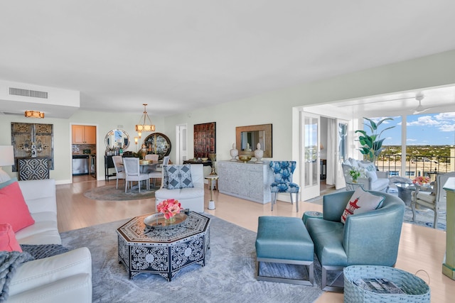 living room featuring an inviting chandelier and light hardwood / wood-style flooring