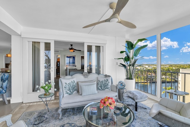 sunroom with ceiling fan, a healthy amount of sunlight, and a water view