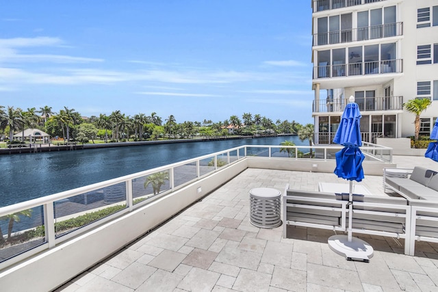 view of patio with a water view, a balcony, and an outdoor hangout area