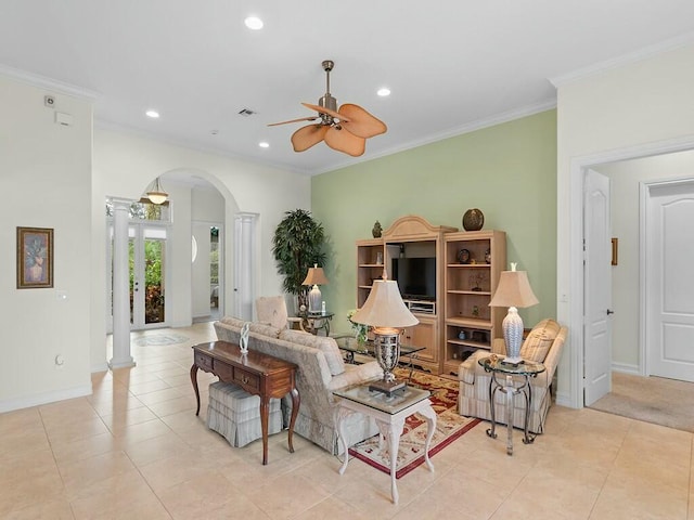 tiled living room featuring decorative columns, crown molding, and ceiling fan