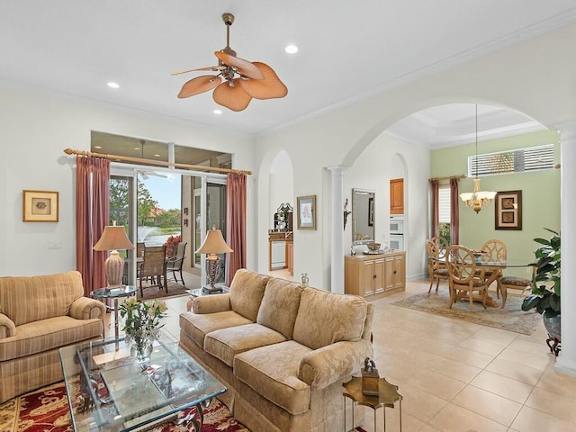 living room with ceiling fan with notable chandelier, ornamental molding, decorative columns, and light tile patterned flooring