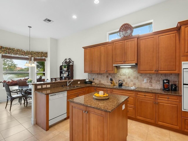 kitchen featuring sink, dishwasher, a center island, decorative light fixtures, and kitchen peninsula