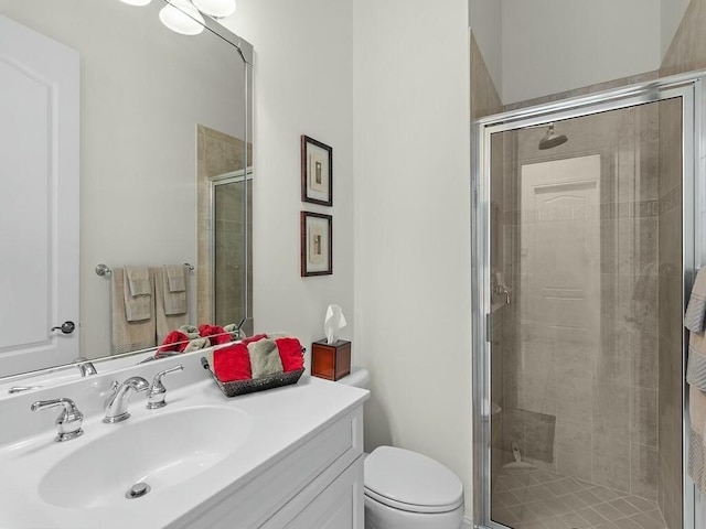 bathroom with walk in shower, vanity, and toilet