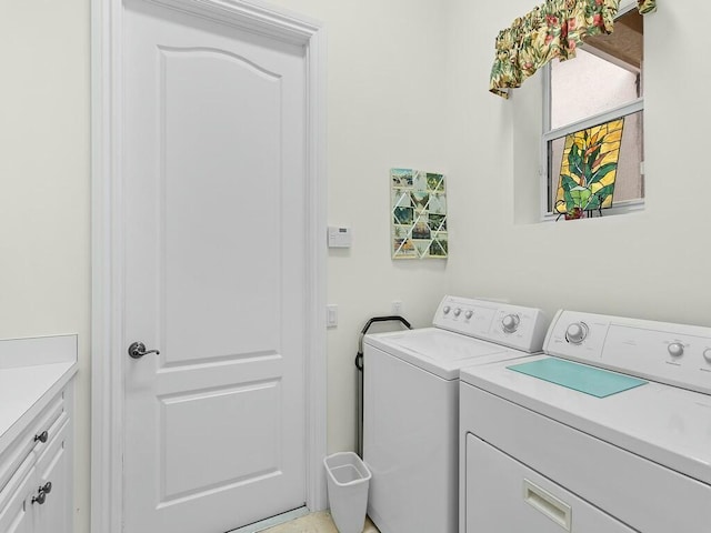 laundry area featuring washing machine and dryer and cabinets