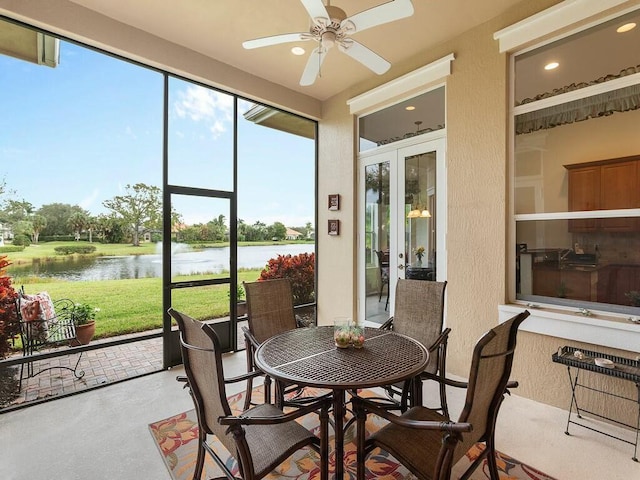 sunroom with a water view, ceiling fan, and french doors