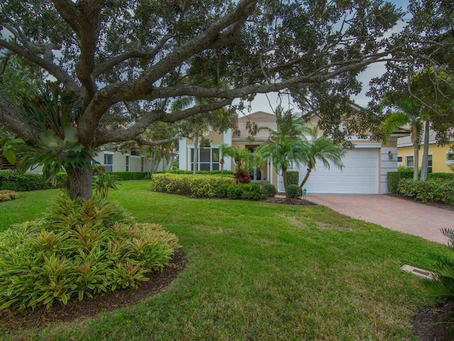 obstructed view of property with a garage and a front lawn