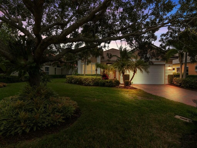 view of front facade with a yard and a garage