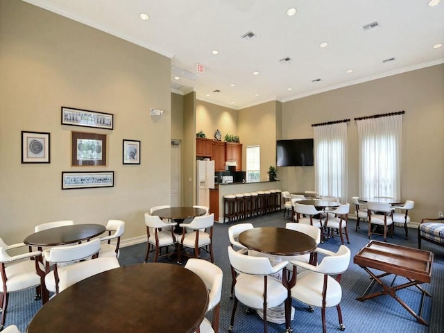 carpeted living room with a towering ceiling and ornamental molding