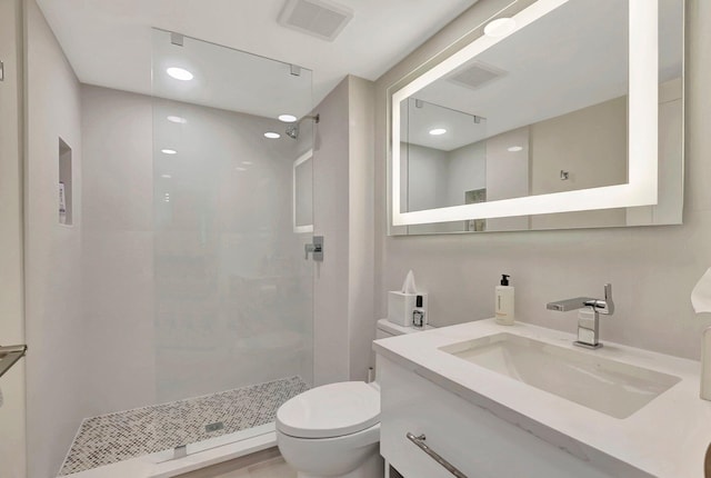 bathroom featuring tiled shower, vanity, and toilet