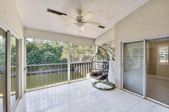 unfurnished sunroom with vaulted ceiling and ceiling fan