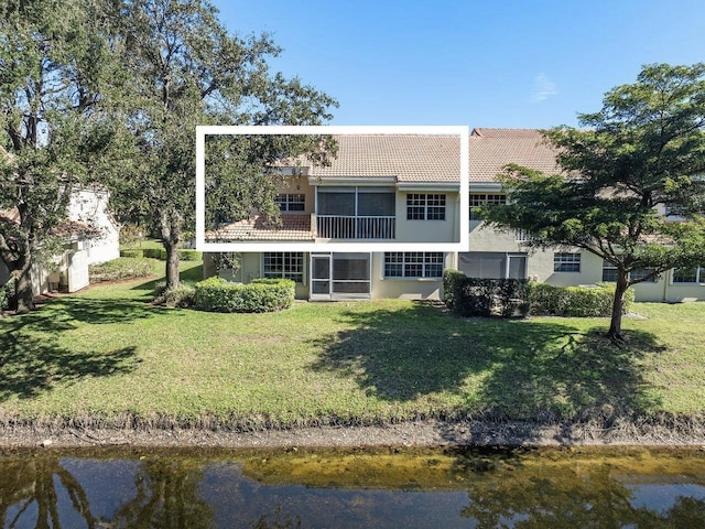 back of house with a yard and a water view