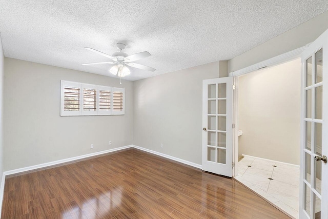 spare room featuring wood-type flooring, ceiling fan, a textured ceiling, and french doors