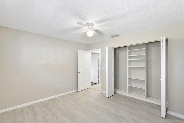 unfurnished bedroom with ceiling fan, light hardwood / wood-style floors, a closet, and a textured ceiling