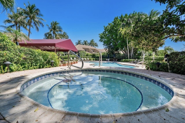 view of swimming pool featuring an in ground hot tub