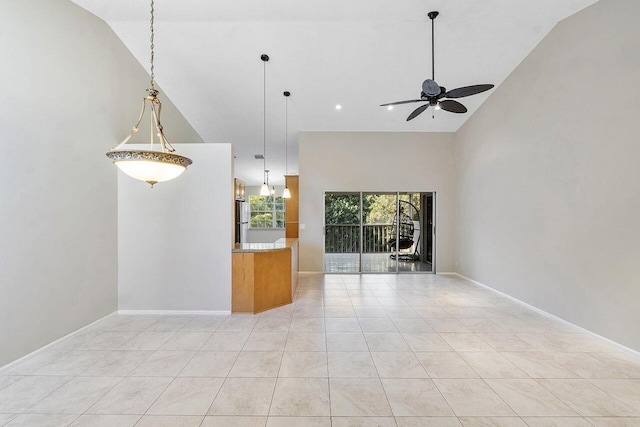 tiled empty room featuring ceiling fan and vaulted ceiling